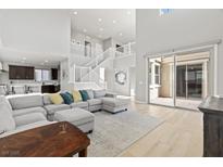 Bright, open living room with high ceilings, modern decor, and sliding glass doors to outdoor space at 3062 Echoed Rondel Ln, Henderson, NV 89044