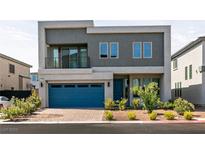 Modern two-story home featuring a blue garage door, minimalist landscaping, and a small second story balcony at 363 Terrill Ave, Las Vegas, NV 89183