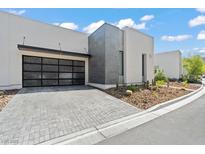 Modern home featuring a unique glass-paneled garage door and desert landscaping at 650 Scenic Cliff Dr, Henderson, NV 89012