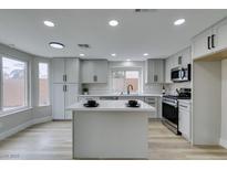 Bright kitchen with white cabinets, stainless steel appliances, and a center island at 71 Sea Holly Way, Henderson, NV 89074