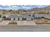 Inviting single-story home with blue siding, four-car garage and mountain views at 261 W Cypress Dr, Henderson, NV 89015