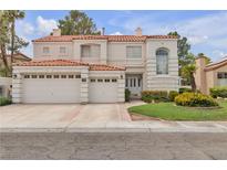 Charming two-story home showcasing a three-car garage and well-manicured lawn with mature trees at 2617 Huber Heights Dr, Las Vegas, NV 89128
