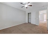 Bright bedroom featuring neutral walls, plush carpet, and a ceiling fan for added comfort at 2617 Romarin Ter, Henderson, NV 89044