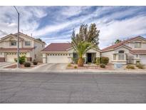 Charming single story home with mature landscaping, a red tile roof, and a two car garage at 50 Mesquite Village Cir, Henderson, NV 89012