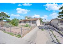 Single story home with a large driveway and fenced yard on a clear day at 916 Putnam Ave, North Las Vegas, NV 89030