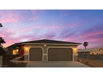 Charming single-story home featuring a two-car garage and desert landscaping at 1931 Rose Ct, Pahrump, NV 89048