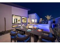 Outdoor patio with dining table, seating, modern architecture, and a pool glowing at dusk at 794 Willits St, Las Vegas, NV 89138