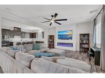 Open-concept living room features a fireplace, entertainment center, ceiling fan and modern decor at 8245 Broad Branch Way, Las Vegas, NV 89113