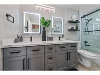 Beautiful bathroom featuring double sinks, gray cabinets, modern fixtures, and a glass shower at 496 Grassrange Ln, Henderson, NV 89052
