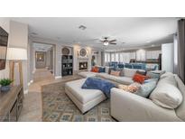 Spacious living room features a cozy fireplace and plush sectional sofa with decorative pillows at 496 Grassrange Ln, Henderson, NV 89052