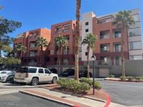 Condominium complex with well-maintained landscaping and palm trees on a clear, sunny day at 15 E Agate Ave # 202, Las Vegas, NV 89123