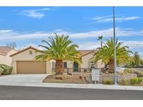 Charming single-story home featuring a well-manicured front yard, desert landscaping, and two palm trees at 2429 Wisconsin Dells Dr, Henderson, NV 89044
