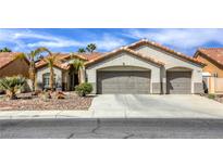 Charming stucco home with a three car garage, desert landscaping, and a red tile roof at 5437 Escallonia St, Las Vegas, NV 89149