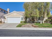 Charming single-story home featuring a well-maintained front yard and a two-car garage at 64 Chateau Whistler Ct, Las Vegas, NV 89148