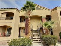 Inviting condo complex with charming architecture, palm trees, and access stairs at 7885 W Flamingo Rd # 2153, Las Vegas, NV 89147