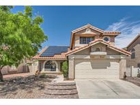 Two-story home with red tile roof, solar panels, two-car garage, brick steps and low maintenance landscaping at 8324 Brittany Harbor Dr, Las Vegas, NV 89128