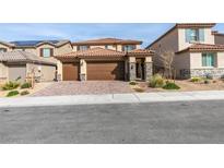Charming two-story home featuring a three car garage, stone accents, manicured landscaping, and a brick driveway at 844 Aurelie Ridge St, Henderson, NV 89011