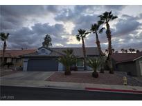 Charming single-story home featuring desert landscaping, mature palm trees, and a two-car garage at 853 Rusty Anchor Way, Henderson, NV 89002
