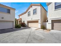 Exterior of home featuring a two-car garage, tile roof, and desert landscaping in a bright setting at 1405 Sycamore Spring Ct, Las Vegas, NV 89128