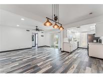 Inviting living room and kitchen with open space, white cabinetry, and striking weathered wood-style flooring at 1405 Vegas Valley Dr # 236, Las Vegas, NV 89169