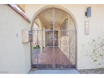 Inviting gated entrance to home with wrought iron gate and desert landscape at 1709 Chapman Dr, Las Vegas, NV 89104