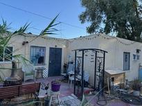 A cozy backyard featuring a vintage fireplace, quaint furniture, and string lights, creating a charming outdoor space at 2520 Sunrise St, Las Vegas, NV 89101