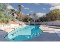 Sparkling pool with lounge chairs, mature trees, and white gazebo create a serene backyard oasis at 5010 Mick Pl, Las Vegas, NV 89103