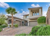 Stunning two-story home with a three-car garage, desert landscaping, and a brick driveway at 19 Hilltop Crest St, Henderson, NV 89011