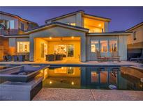 Backyard pool reflecting the home's covered patio with outdoor seating, offering a relaxing oasis at 19 Hilltop Crest St, Henderson, NV 89011