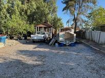 An exterior view of a home featuring a large gravel area, a white pickup truck, and miscellaneous stored items at 2510 Sunrise St, Las Vegas, NV 89101