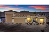Charming single-story home featuring desert landscaping and a spacious three-car garage at 3665 Cottage Stone Ct, Laughlin, NV 89029
