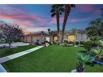 Charming home with lush green lawn, palm trees, and a three-car garage, perfect for families seeking comfort and style at 4722 Blue Mesa Way, Las Vegas, NV 89129