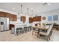 Bright, eat-in kitchen with an island, stainless steel appliances, and modern pendant lighting at 10160 Tree Blossom Ave, Las Vegas, NV 89166