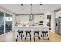 Modern kitchen featuring a spacious island, pendant lighting, stainless steel appliances, and ample cabinet space at 10332 Stroma Ave, Las Vegas, NV 89166