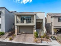 Charming two-story home features a balcony, well-manicured landscaping, and a brick driveway at 10806 Space Odyssey Ave, Las Vegas, NV 89129