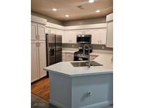 Bright kitchen features white cabinets, stainless steel appliances, and quartz countertops at 5155 W Tropicana Ave # 2089, Las Vegas, NV 89103