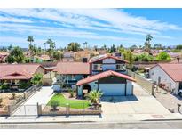 Charming home featuring a red tile roof, landscaped front yard, and an attached two-car garage at 5301 Kalmia Dr, Las Vegas, NV 89103