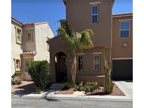 Charming two-story townhome featuring stucco exterior, a quaint entrance, and desert landscaping at 5380 Flowing Spring St, Las Vegas, NV 89122