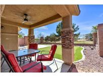 Inviting covered patio with outdoor seating and a built-in putting green for entertainment and relaxation at 5681 Harbour Pointe Ave, Las Vegas, NV 89122