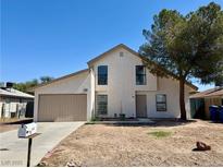 Two-story home with a two-car garage, neutral tones, and a xeriscaped front yard under a clear, blue sky at 5928 Willard St, Las Vegas, NV 89122