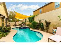 Beautiful pool with tiled jacuzzi, seating, and lovely landscaping in backyard at 115 Cora Hills Ct, Las Vegas, NV 89148