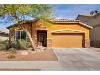 Charming single-story home featuring a two car garage and a desert landscape with a lovely tree in the front yard at 1152 Pine Cove Ct, Henderson, NV 89011