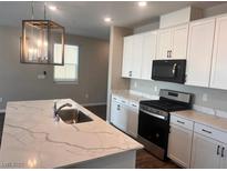 Modern kitchen with a marble-patterned island countertop, bright lighting, and sleek white cabinetry at 3481 Bradano Ln, Henderson, NV 89044