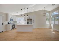Bright, open kitchen with white cabinets, stainless steel appliances, and a kitchen island at 4010 Herblinda Ln, North Las Vegas, NV 89032