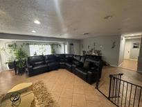 Inviting living room featuring a large sectional sofa and abundant natural light from the window at 4825 E Monroe Ave, Las Vegas, NV 89110