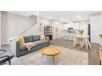 Cozy living room with a grey sofa, round wood table, and access to the open kitchen at 6239 Milford Sound St, Las Vegas, NV 89148