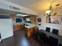 Traditional kitchen featuring wooden cabinets and granite countertops, adjoining the dining area at 898 Flagstone Way, Las Vegas, NV 89110