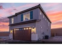 Charming two-story home with a brown garage door, gray paint and a beautiful sunset at 9671 S Conquistador St # Lot 18, Las Vegas, NV 89178