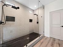 Modern bathroom featuring sleek glass shower, rainfall shower head, and mosaic tile floor at 8276 Aurora Peak Ave, Las Vegas, NV 89131