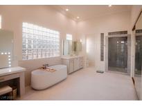 Bright bathroom featuring a soaking tub, walk-in shower, dual vanities, and ample natural light at 9 Knob Oak Dr, Henderson, NV 89052